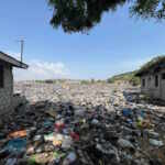 Textiles and other plastic waste outside houses at the Weija Ashbread landfill, an older textile dump site upriver from the Densu Delta protected wetlands, outside Accra, Ghana.